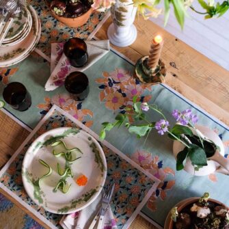 Swans Island Dia Table Runner by Soil to Studio. Block printed by hand in India with bright playful patterns. Shown here in Sage with Yellow floral.