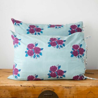 Swans Island Company's Sara Shams by Soil to Studio. Block printed by hand in India with bright playful patterns. Shown here in Denim with roses.