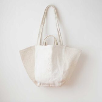 Swans Island Company's Anya Embroidered Tote bag by Govou. Upcycled antique grain sacks are reimagined into unique tote bags. This one features hand-stitched seashore embroidery motifs. Shown here in natural colorway.