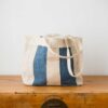Swans Island Company's Govou Quilted Tote Bag is madein Spain. Antique grain sacks are reimagined into unique tote bags. Shown here in nature with Indigo Blue.