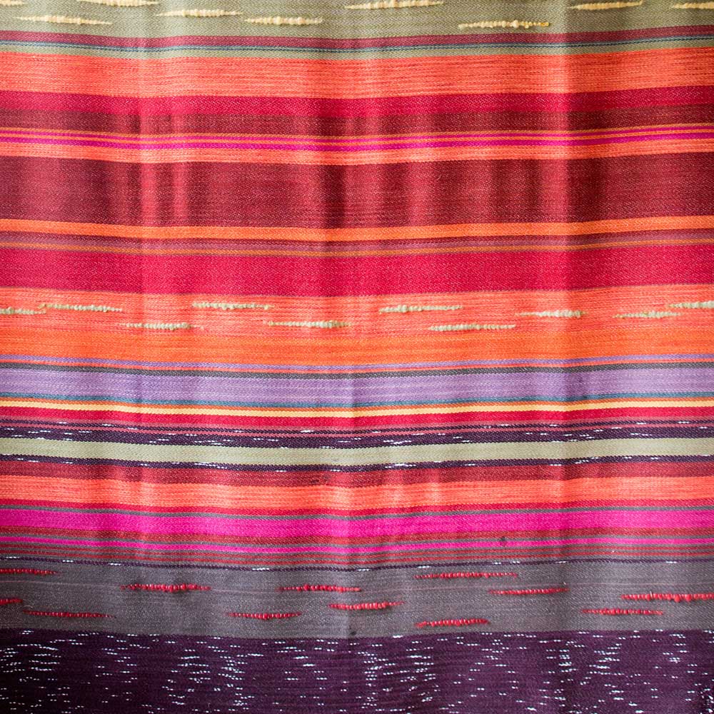 Swans Island Company's 2025 Limited Edition "Autumn in New England" Throw commemorates Yankee Magazines' 90th anniversary. This handwoven throw features 90 color changes in vibrant autumn hues of hand-dyed color. Made in Maine. Limited supply. Closeup Detail of a portion of the throw.