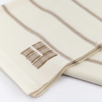 Casa Branca x Swans Island - Branca Ticking Stripe Throw . 100% soft merino wool with hand-dyed stripes and ivory silk binding. Handwoven in Maine. Shown here in Biscotti.